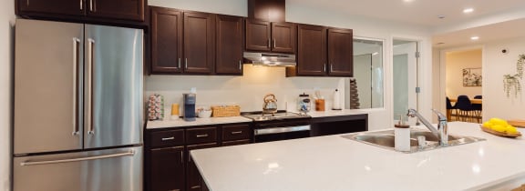 a large white counter top in a kitchen with stainless steel appliances