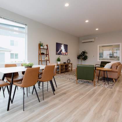 A dining room with a white table and chairs.