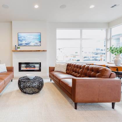 a living room with two leather couches and a fireplace