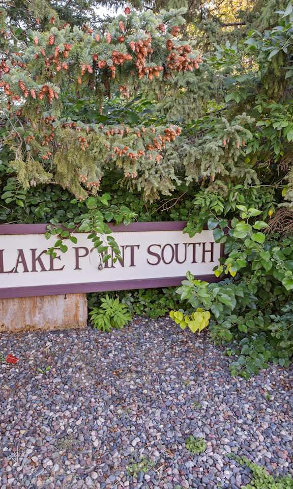 a sign for lake path south in front of some trees
