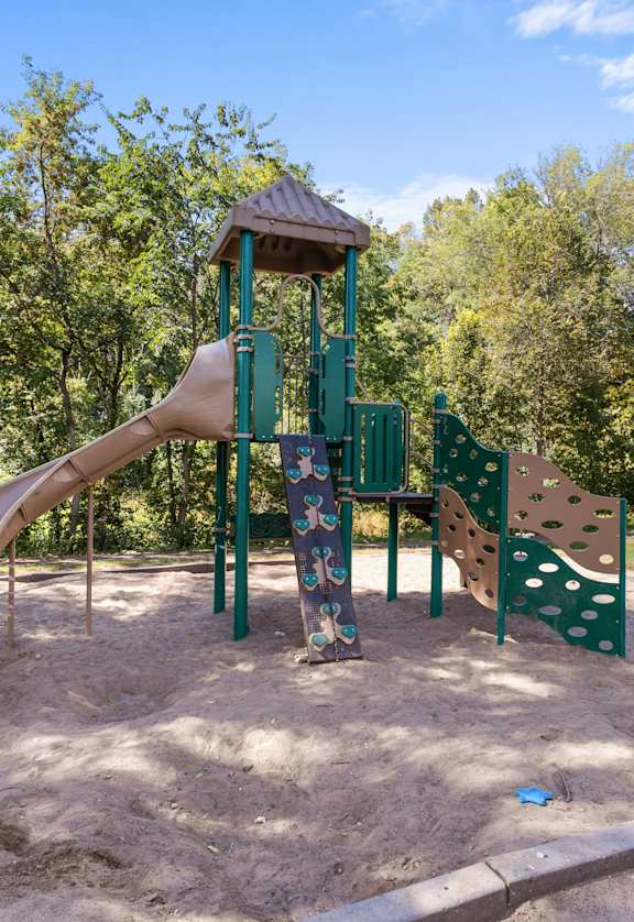 A playground with a slide and a wooden structure.