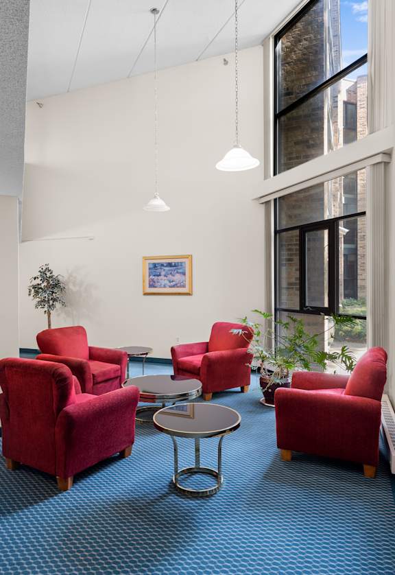 A room with red chairs and a blue carpet.
