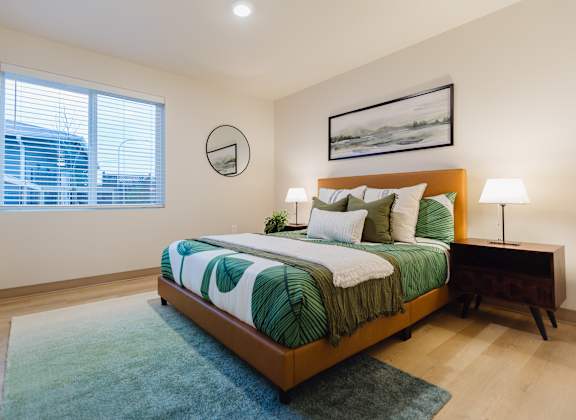 A bedroom with a bed, nightstand, and lamp.