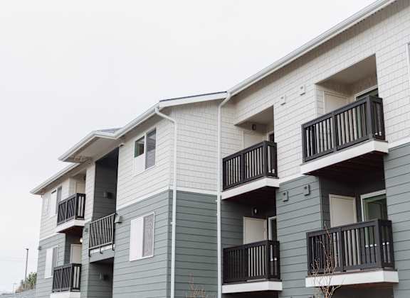 Apartment building with balconies and doors.