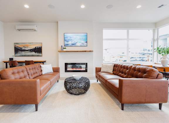 a living room with two leather couches and a fireplace