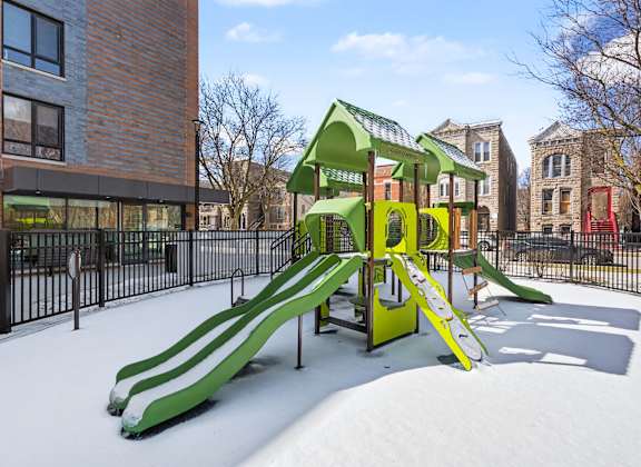 A playground with a green and yellow slide.