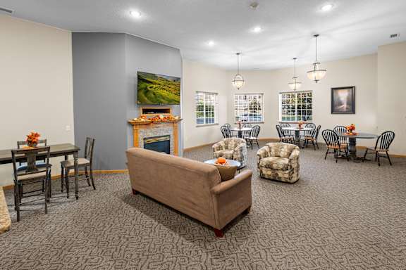 A living room with a couch, chairs, and a television.