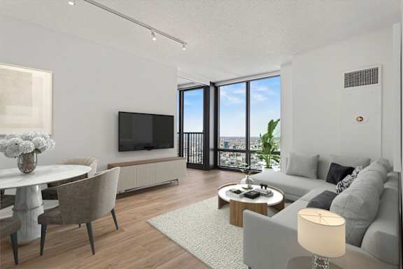 A modern living room with a grey sofa, a white coffee table, and a flat screen TV.