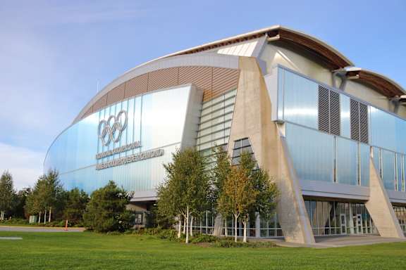 A modern building with a curved glass facade and a logo on it.