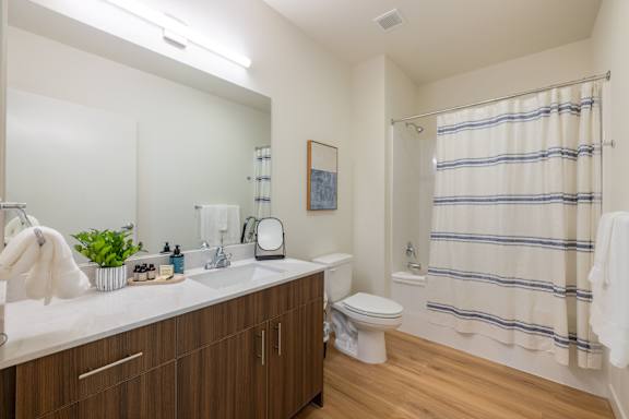 A bathroom with a toilet, sink, and shower.