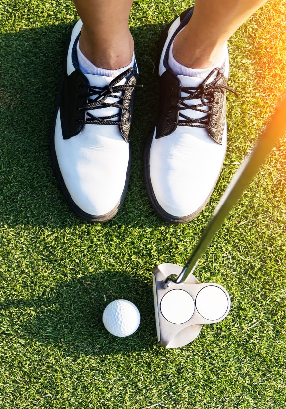 a woman in tennis shoes is standing next to a golf ball