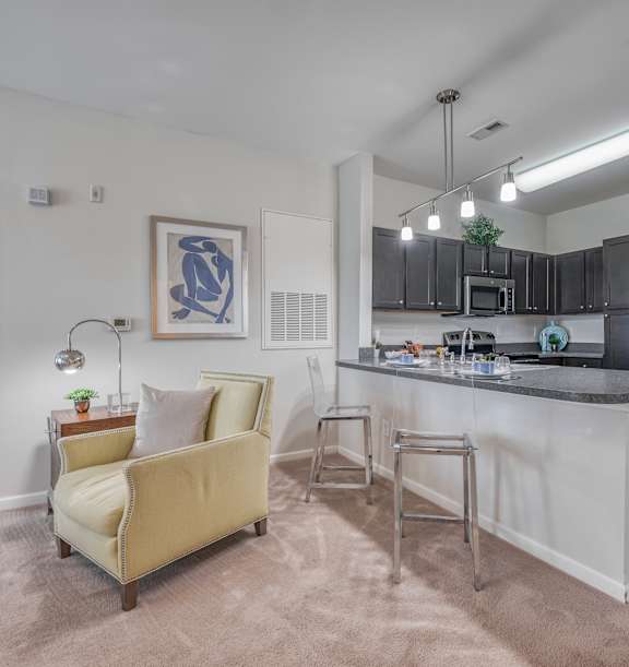 A kitchen with a white island and a yellow chair.