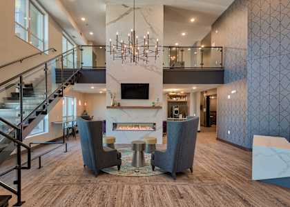 A modern living room with a staircase and a fireplace.
