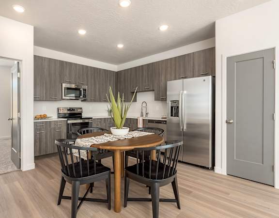 A modern kitchen with a dining table set for four.
