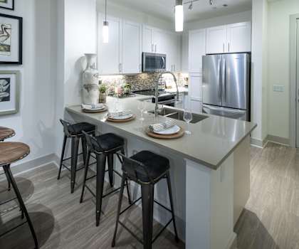 A kitchen with a bar area and a refrigerator.
