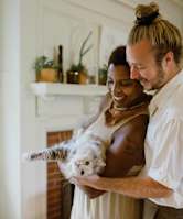 a man and a woman holding a white dog