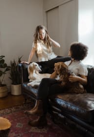 two women sitting on a couch with two dogs at Union Arms, Washington, 98122