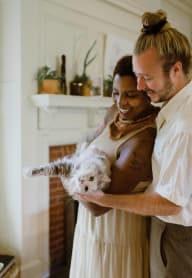 a bride and groom hold their dog