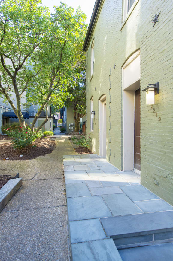 the sidewalk in front of the building is lined with trees at Queen Anne Belvedere, Maryland, 21201
