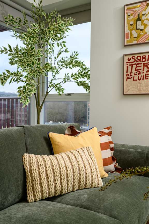 A bedroom with a bed, a window with curtains, and a picture hanging on the wall.