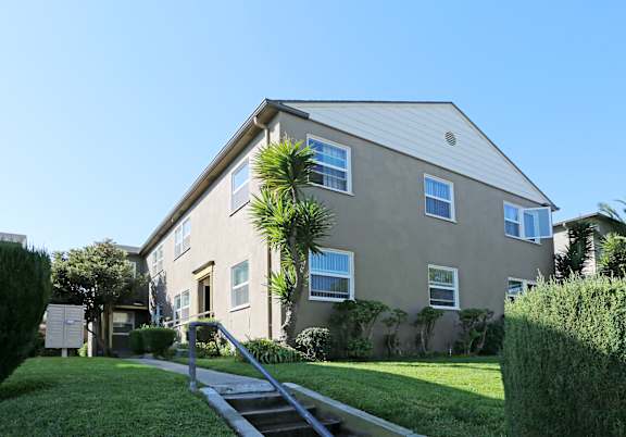 A house with a grey roof and a green lawn in front.