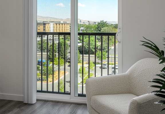 a room with a balcony and a chair and a window