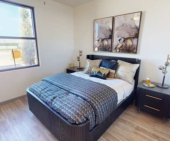 A bedroom with a large bed and a window overlooking a parking lot.