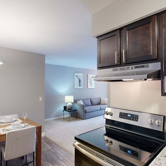 A modern kitchen with a dining table set for two.