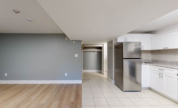 A kitchen with a refrigerator, oven, and cabinets.