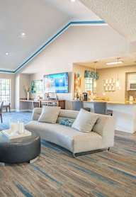A living room with a grey couch and a round table.
