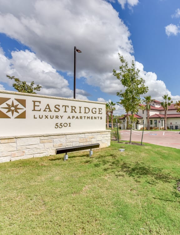 the entrance to luxury apartments sign with buildings in the background