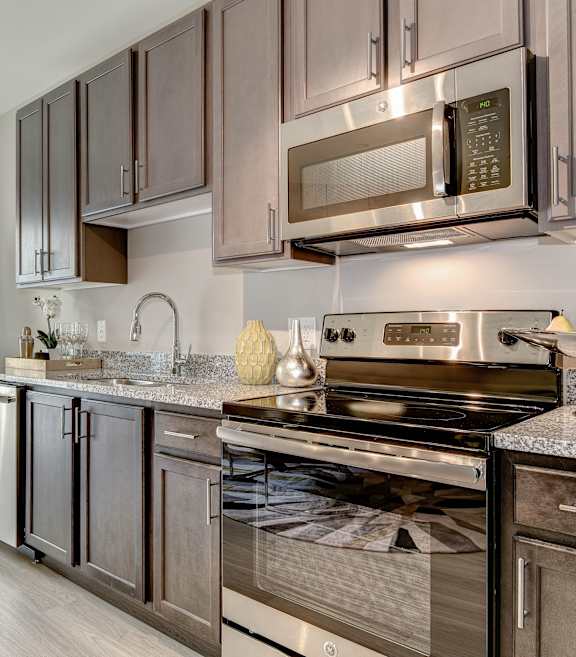 a kitchen with gray cabinets and stainless steel appliances at Ascend Apollo Apartments, Largo, MD, 20774
