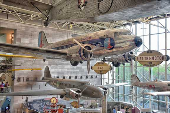 A large airplane is suspended from the ceiling in a museum.