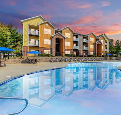a swimming pool with an apartment building in the background