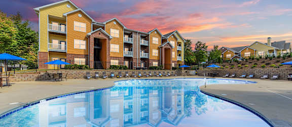 a swimming pool with an apartment building in the background