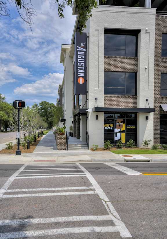 an empty street in front of a building with a sign on the side