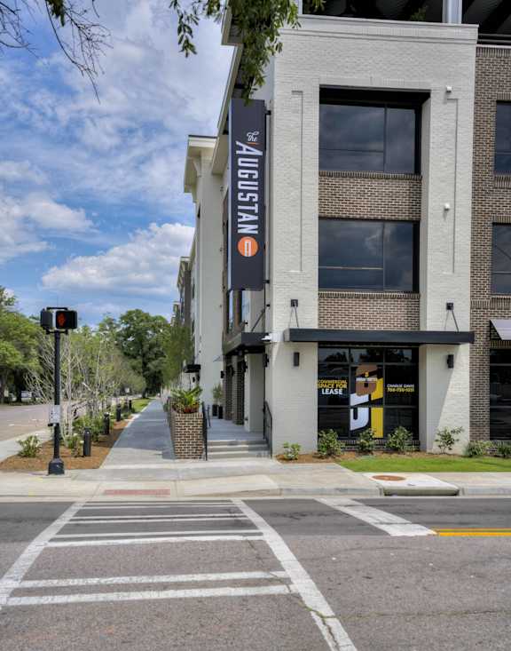 an empty street in front of a building with a sign on the side