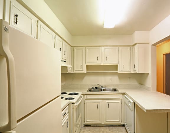 a kitchen with white cabinets and white appliances at Foxcroft Apartments, Florida 89103