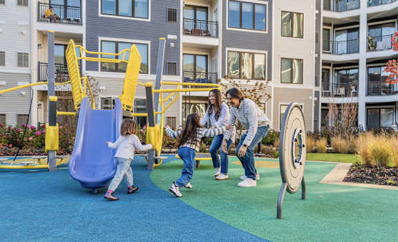 a family playing on a playground at an apartment complex