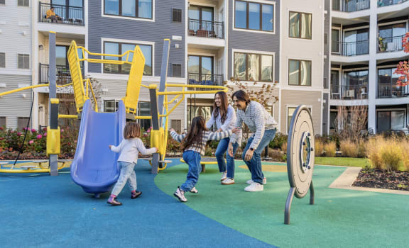 a family playing on a playground at an apartment complex