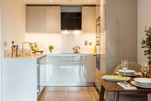 a kitchen with white cabinets and a wooden table