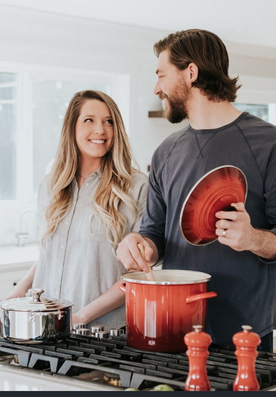 a man and woman standing in a kitchen stirring a pot on a stove at Icon Apartments, Washington, 98104