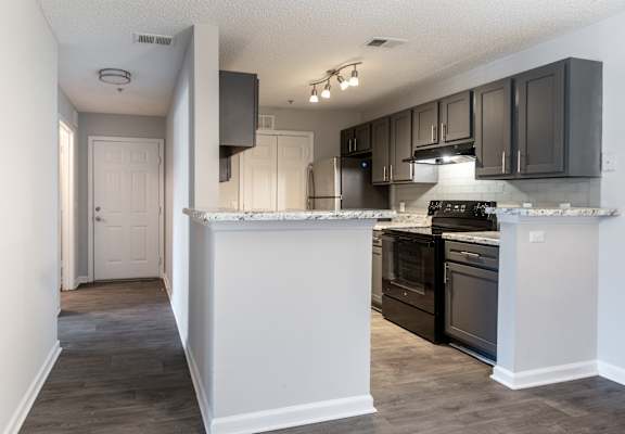 A kitchen with black cabinets and a white countertop.