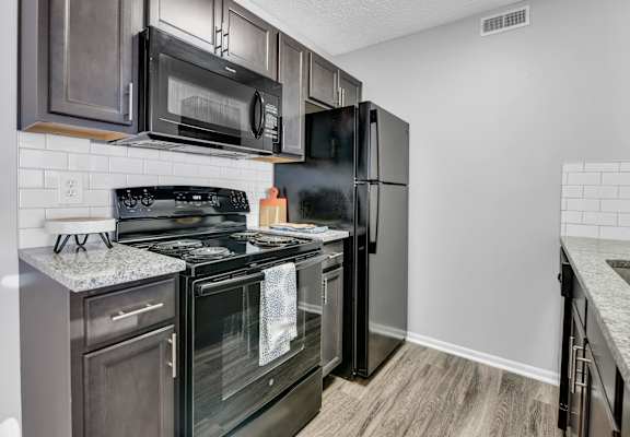 an apartment kitchen with black appliances and stainless steel appliances
