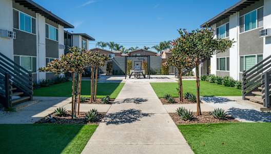 A sunny day at a residential area with apartment buildings and a walkway.