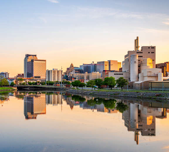 A city skyline is reflected in a body of water.