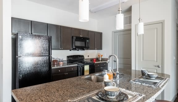 a kitchen with granite counter tops and black appliances