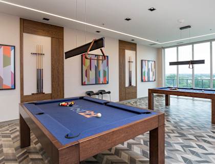 A pool table in a room with a view of the city.
