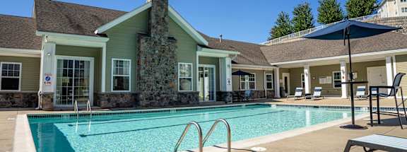 a swimming pool with a house in the background