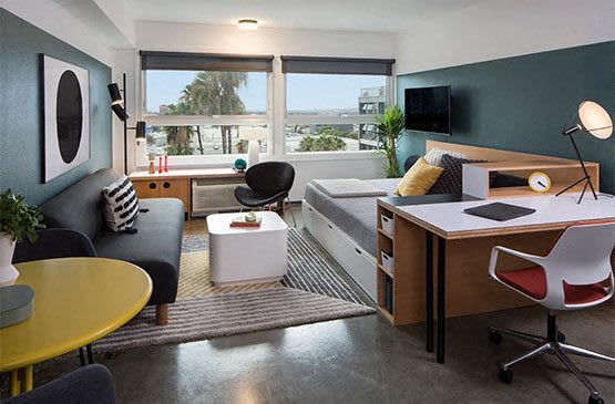 a living room with a couch and a desk at The Flat in Los Angeles, California